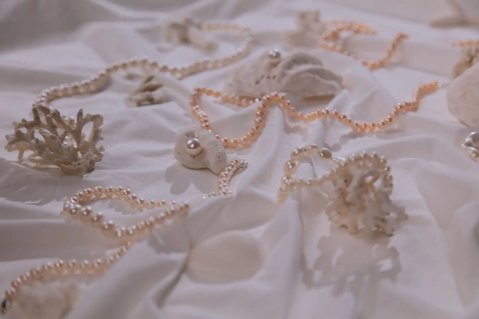 Elegant pearl necklaces displayed on coral representing New Zealand coastal inspiration